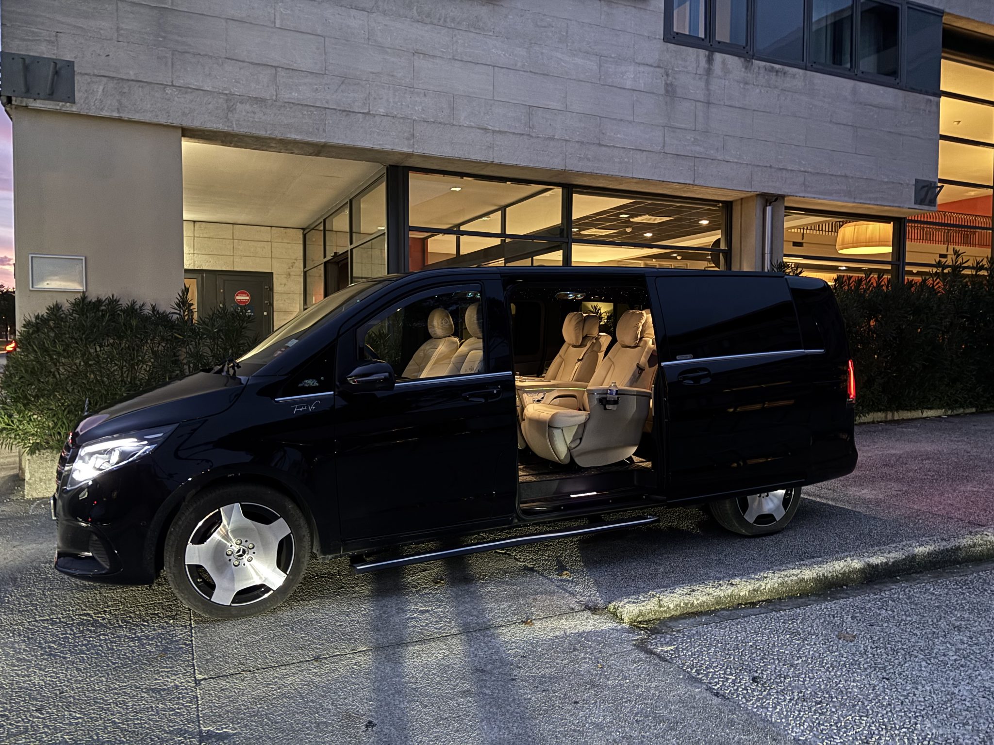 Mercedes Classe VIP noire avec chauffeur privé devant l'hôtel, transfert vers les stations de ski aux Arcs